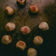 top down view of browned orbs (vegan chicken meatballs) on a distressed metal background