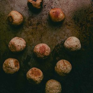 top down view of browned orbs (vegan chicken meatballs) on a distressed metal background