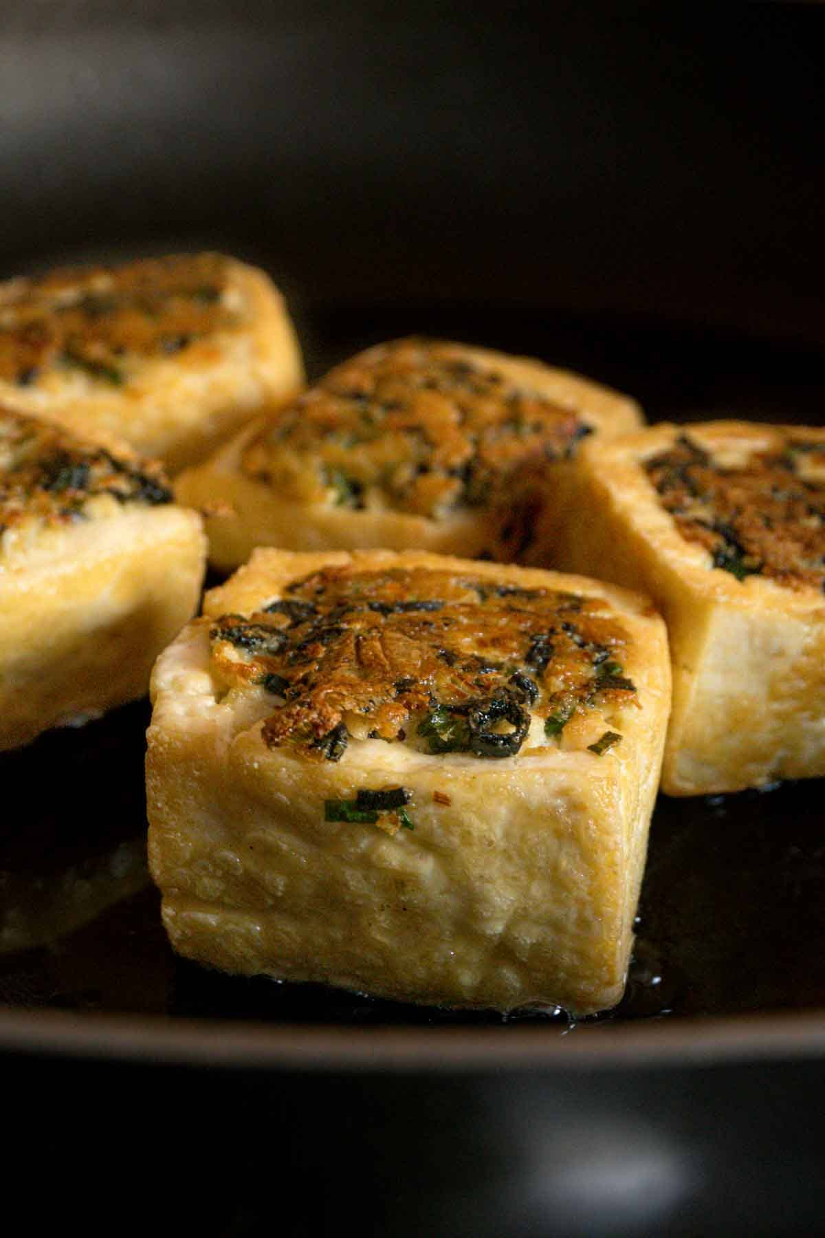 Stuffed tofu being fried in a pan