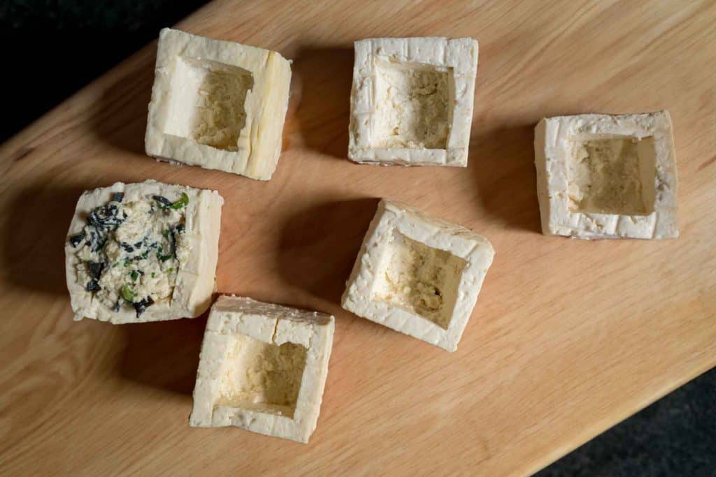6 large squares of tofu with the centres carved out. One is stuffed with lemongrass and spring onion filling