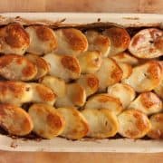 top down view of a rectangular tray of vegan lancashire hotpot topped with crispy golden potato slices