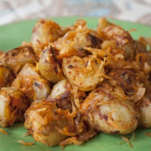 Pile of fried pieces of potato on a green plate