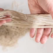 Two hands holding strands of fresh homemade alkaline ramen noodles