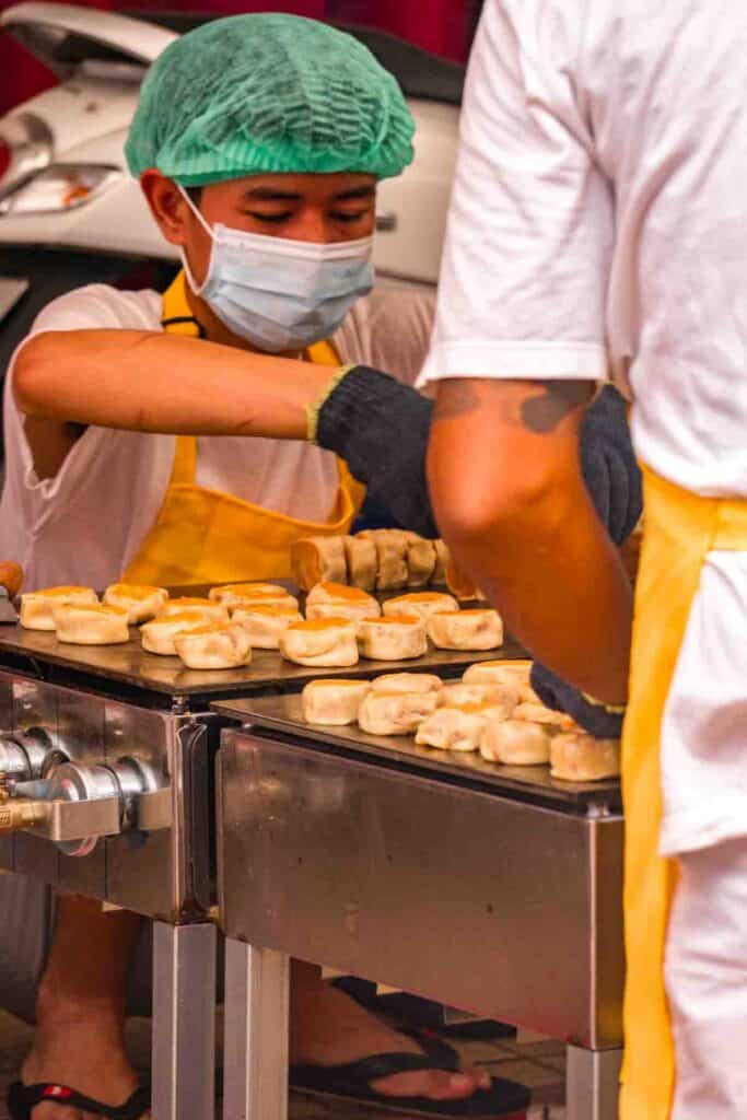 Two men making kanom luk tao, square shaped Chinese pastries