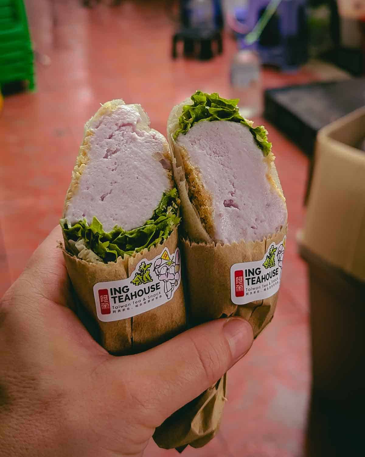 hand holding two halves of a burrito-like ice cream roll