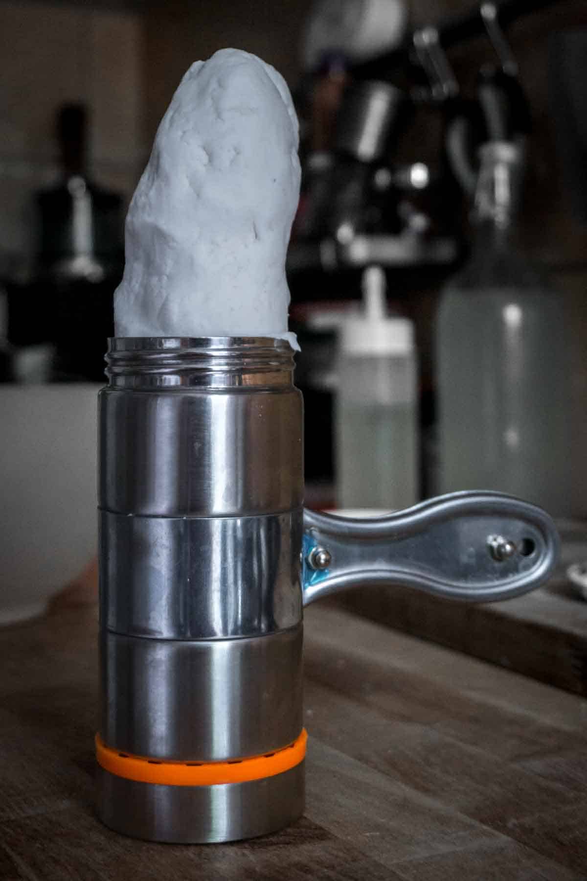 Putting dough into the tube of the handheld noodle press