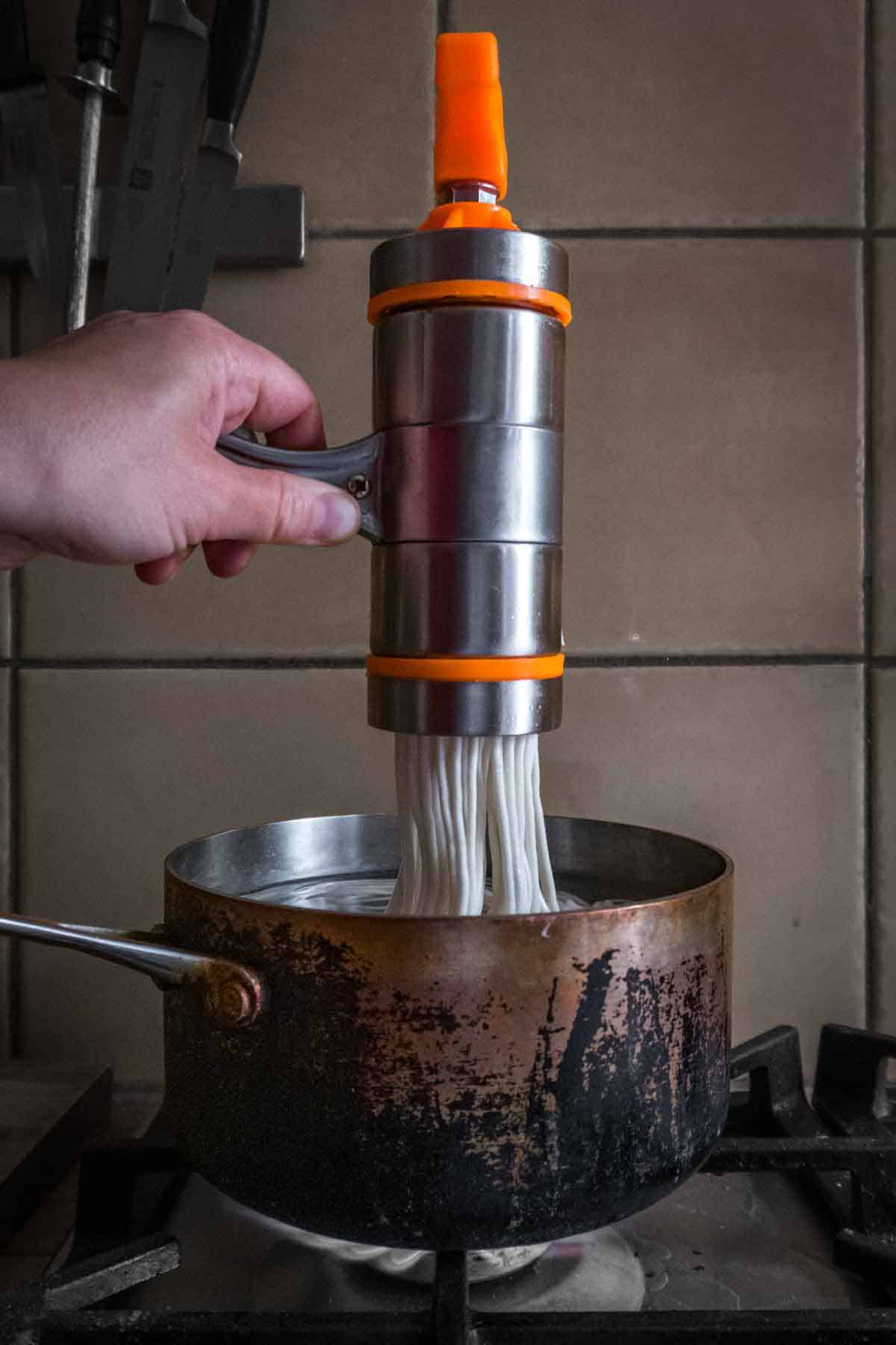 Cranking fresh noodles into boiling water