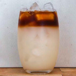 glass ⅘ full with white-ish liquid. The top ⅕ is coffee