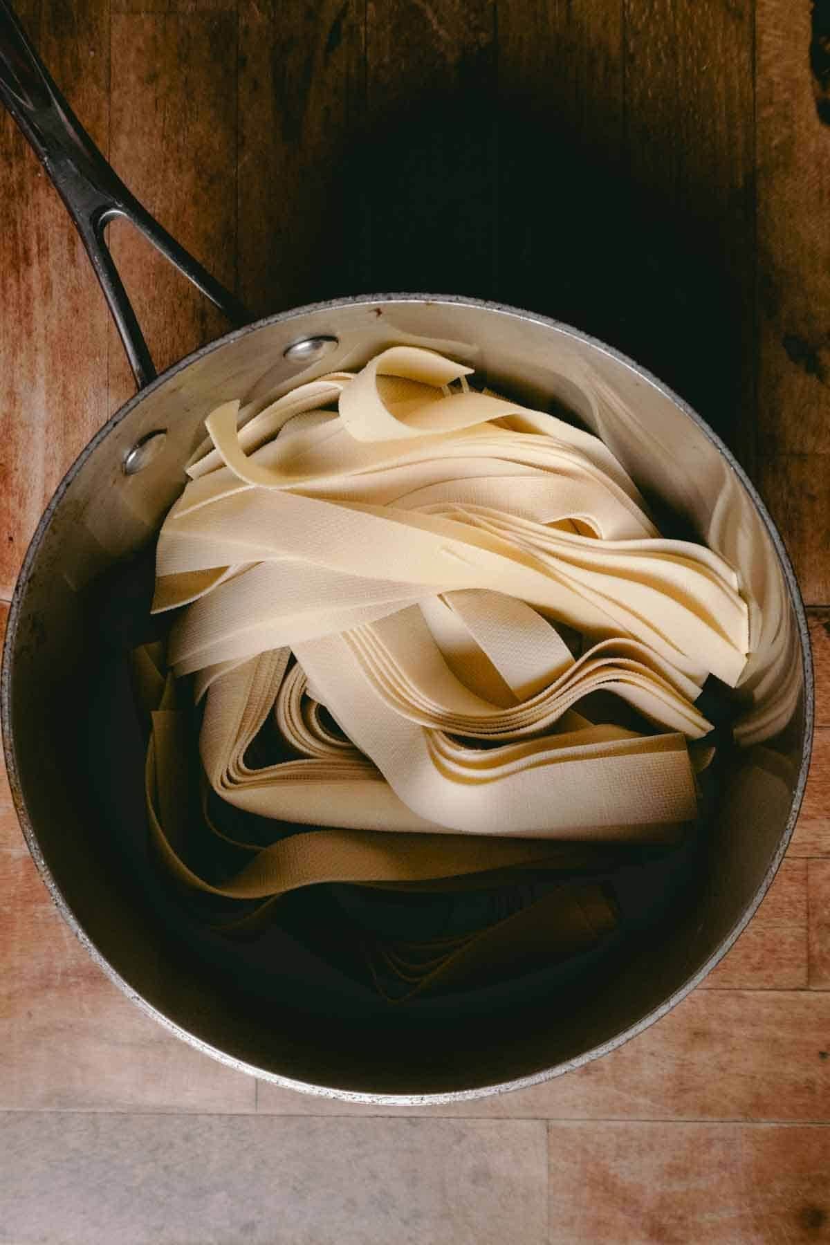 2 cm strips of thin noodle like sheets (pressed tofu sheets) piled in a saucepan