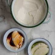 Top down view of a large pot with tofu pudding, next to two small bowls with tofu pudding.
