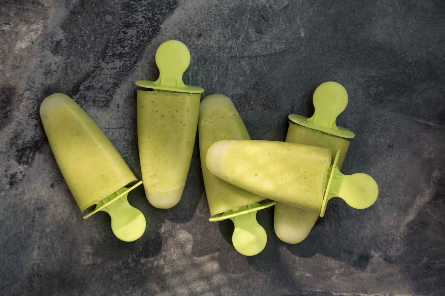 five pineapple thai basil ice lollies on a dark grey surface